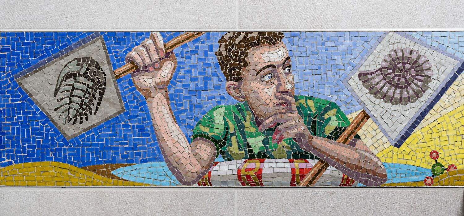 Ausschnitt Mosaikfries "Gezeiten" in Badezimmer zum Thema "Wasser als Ressource" von Wolf v. Waldow, Motiv: Junge im Rettungsring hält Demo-Schilder auf denen Ammoniten und Trilobiten zu sehen sind