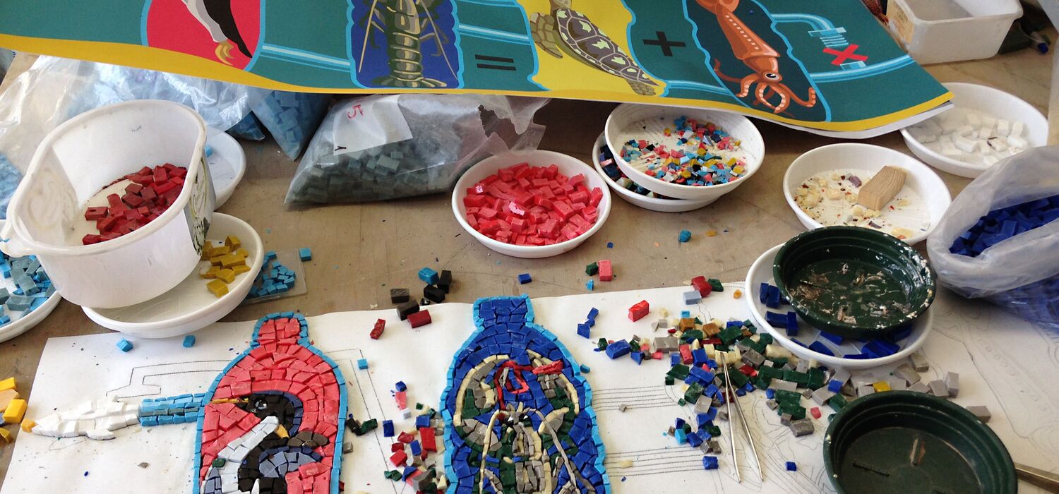 Herstellung Mosaikfries "Gezeiten" von Wolf v. Waldow in Werkstatt Fa. Cosmomusivo; Vorlageentwürfe, Schälchen mit farbigen Mosaiksteinen, halbfertige Motive