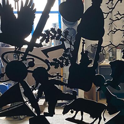 Alter Markt 6, Potsdam - Kunst-Projekt "Wa(a)gnis" von Wolf v. Waldow; scherenschnittartige, schwarze Figurengruppe: Details mit Büste Friedrich II, Puppe, Kuh, Segelschiff, Spielfigur, Krähe die Planetenmodell hält, Eichenkranz mit 1 in Mitte