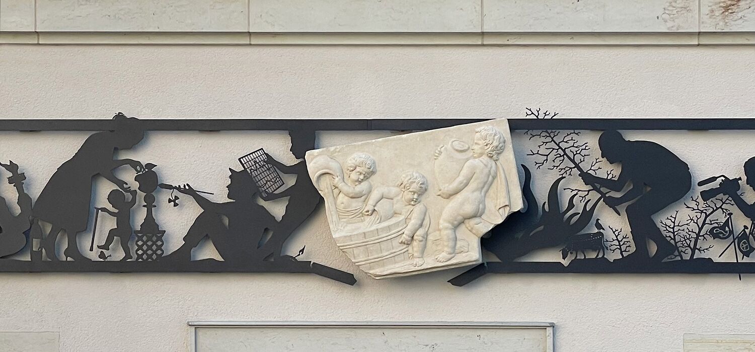 Alter Markt 6, Potsdammit Kunst-Projekt "Wa(a)gnis" von Wolf v. Waldow: Ausschnitt aus scherenschnittartigem, schwarzem Fries über Eingangstür mit Abguss von historischem, Reilieffragment (Christoph Wohler: Putten löschen einen Brand)
