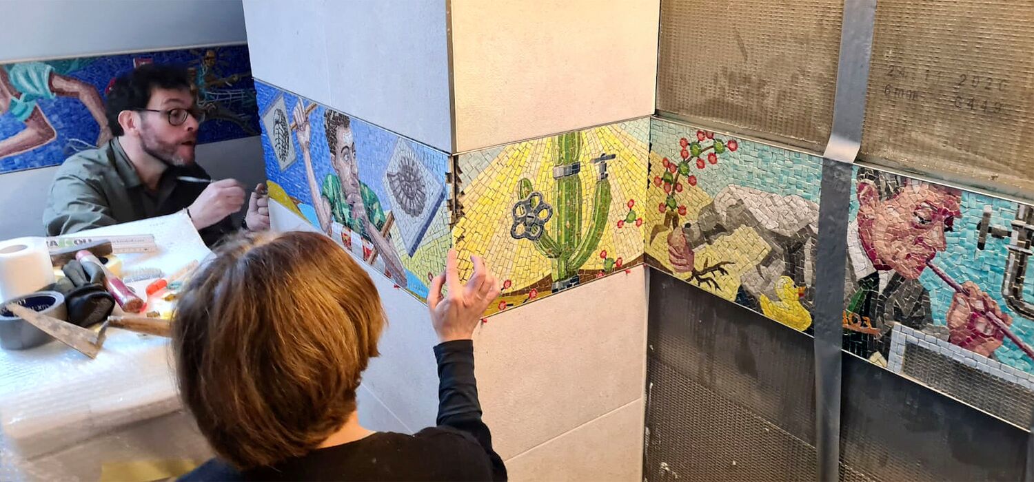Anbringung Mosaikfries in Badezimmer zum Thema "Wasser als Ressource" von Wolf v. Waldow, Mirarbeitende der Firma Cosmomusivo Berlin bei der Arbeit.