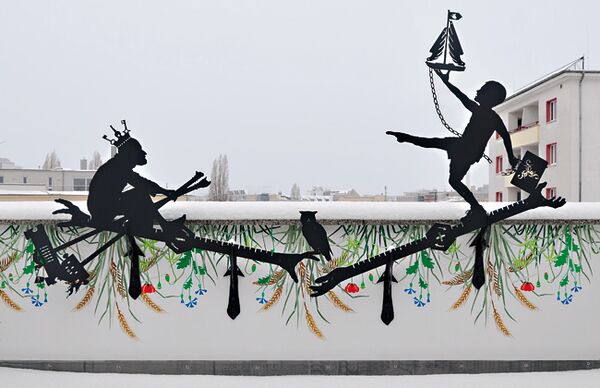 Blick auf die Brüstung einer Dachterrasse in Berlin-Mitte mit figürlichen Silhouetten-arbeit von Wolf v. Waldow darauf, die Wand darunter mit Pflanzen bemalt, im Hintergrund Stadtpanorama Berlins
