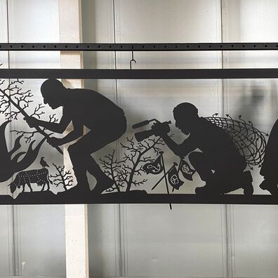 Alter Markt 6, Potsdammit Kunst-Projekt "Wa(a)gnis" von Wolf v. Waldow; Ausschnitt scherenschnittartiger, schwarzer Fries: 1. Mann legt Ast in Feuer, 2. Mann filmt dies, alte Frau mit Aktenkoffer geht nach rechts aus dem Fries hinaus