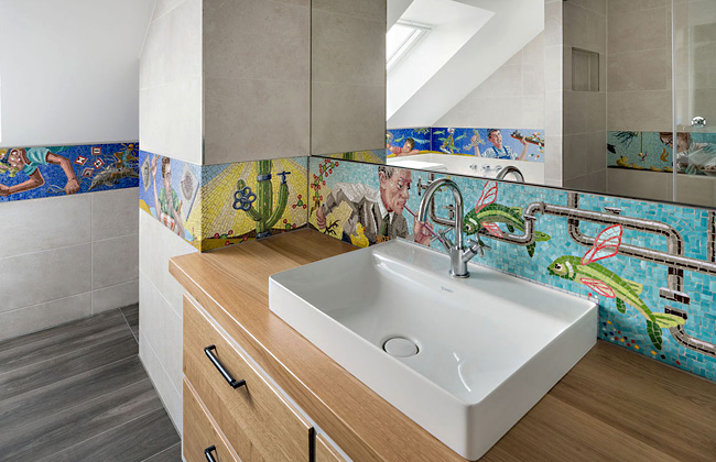 Blick in ein Badezimmer, dessen Wände mit einem Mosaikfries zum Thema "Wasser als Ressource" gestaltet sind